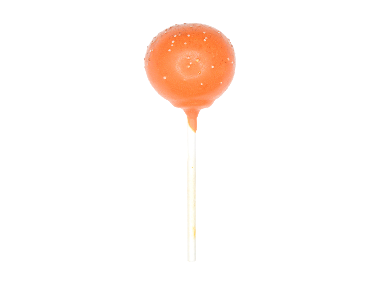 Orange cake pop on a white stick against a black background