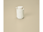 White soap dispenser with ribbed texture on a beige background.