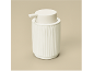 White soap dispenser with a ribbed texture.