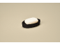 White soap in a black soap dish on a beige background.