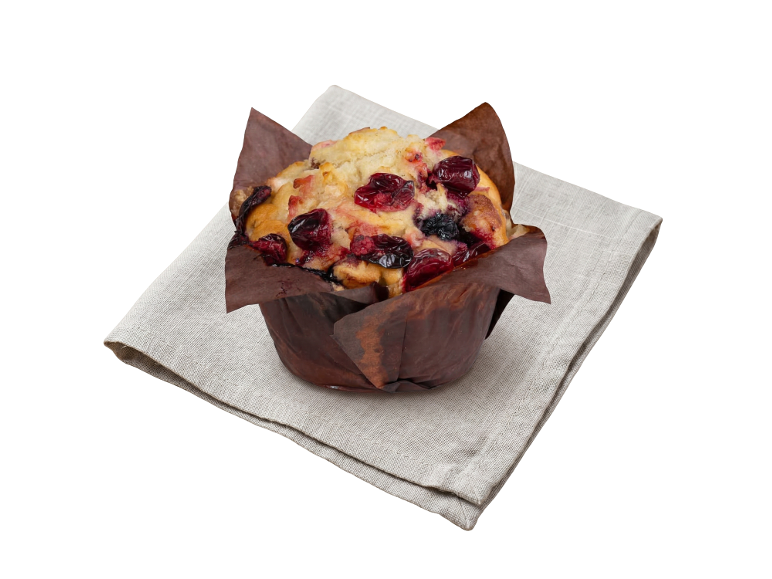 Berry muffin in a brown paper liner, resting on a light linen napkin.