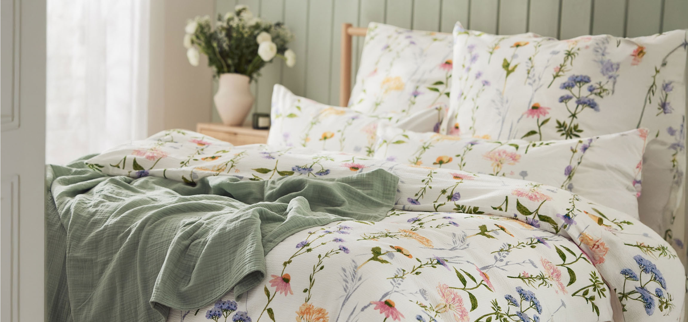 Roupa de cama floral e cobertor.