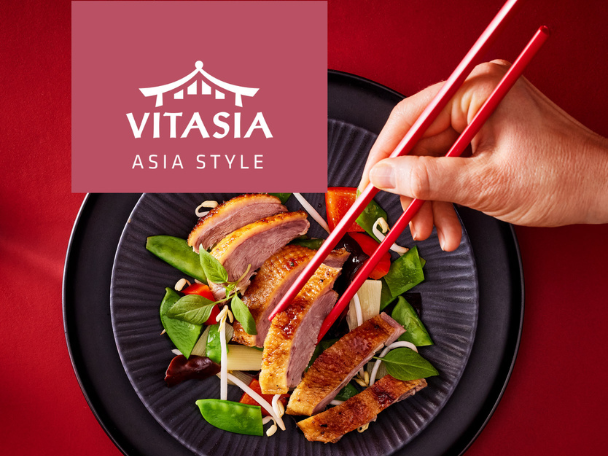 Duck breast with Asian-style vegetables, held by chopsticks, with a logo featuring a pagoda and text.
