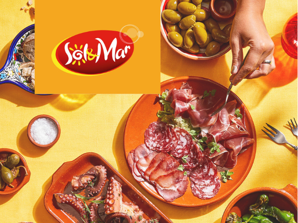 A vibrant spread of Spanish tapas, including cured meats, olives, octopus, and bread.
