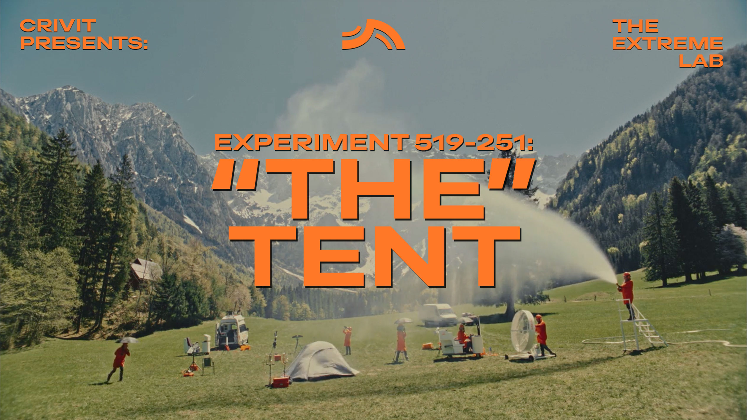 People in orange suits testing a tent and camping equipment in a mountainous setting.