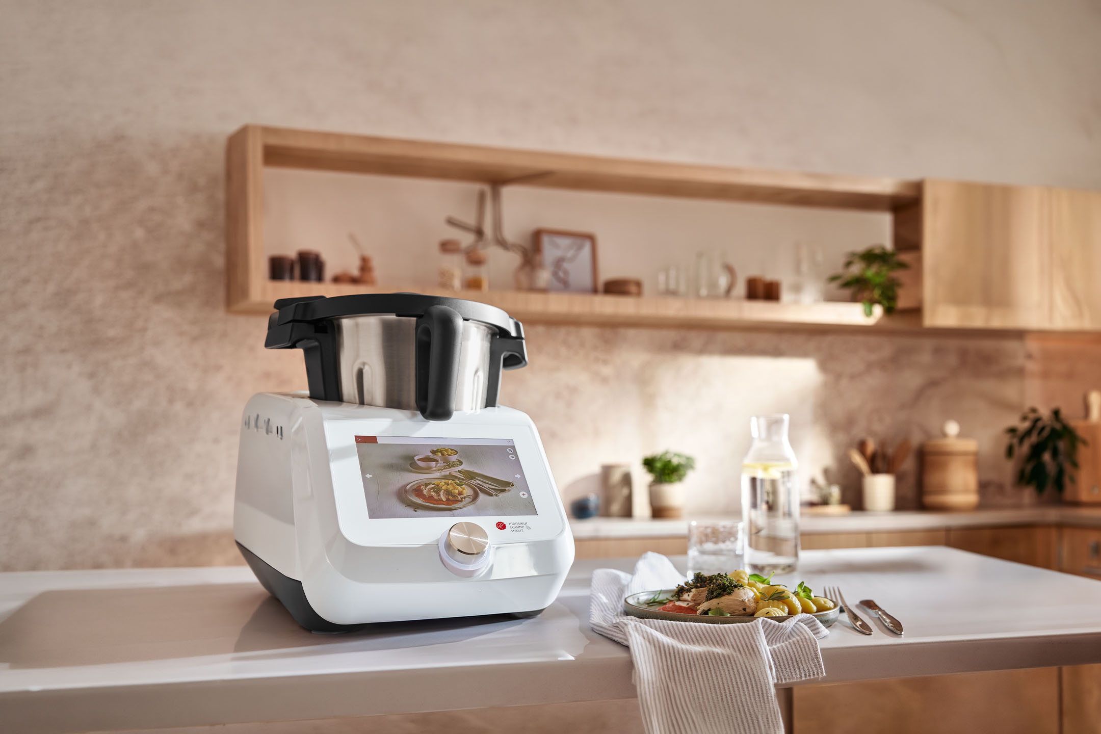 Smart kitchen appliance on a counter with a prepared meal and water bottle in a modern kitchen.