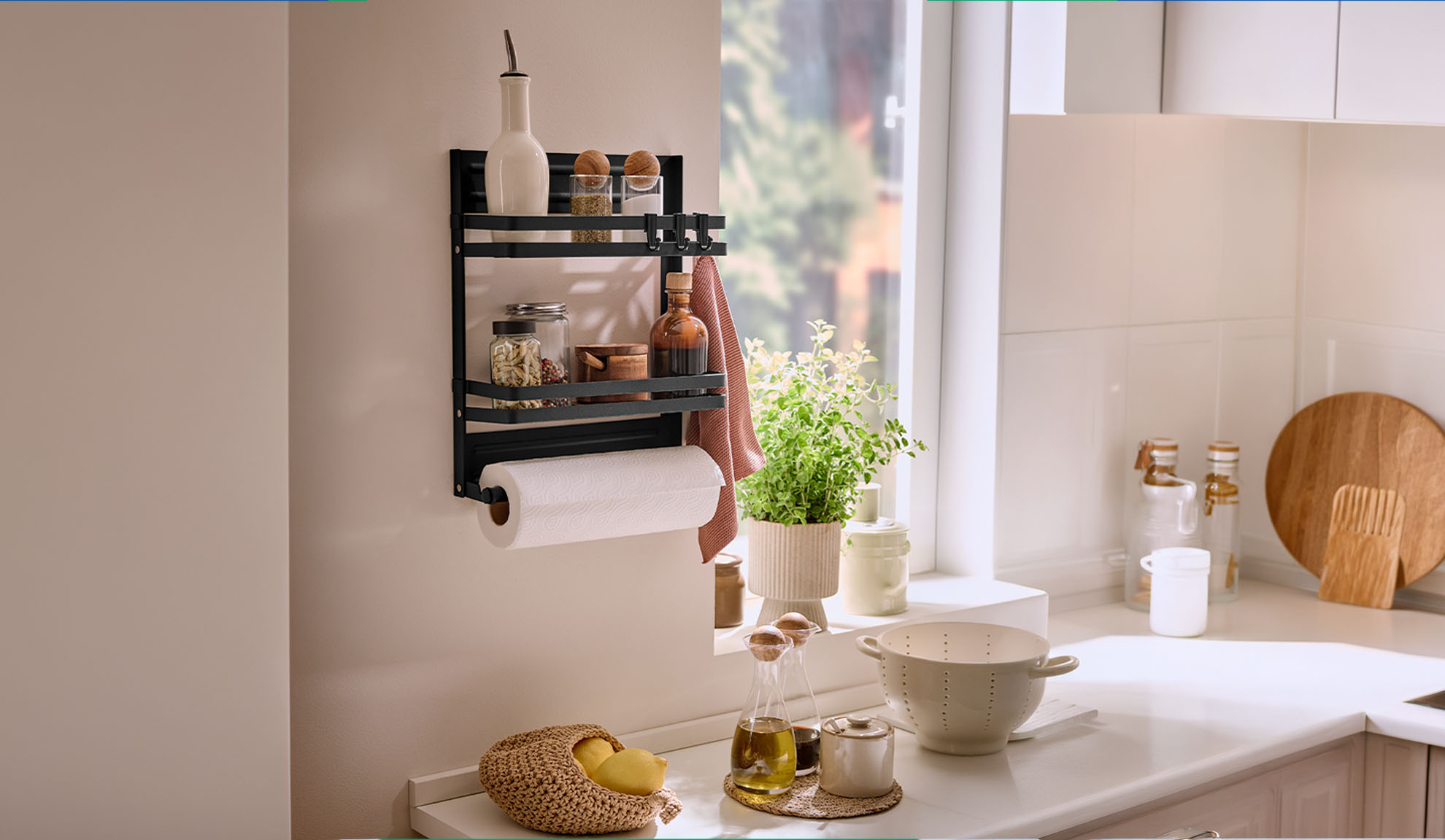 Black kitchen shelf with spices, paper towel, and a plant by the window.