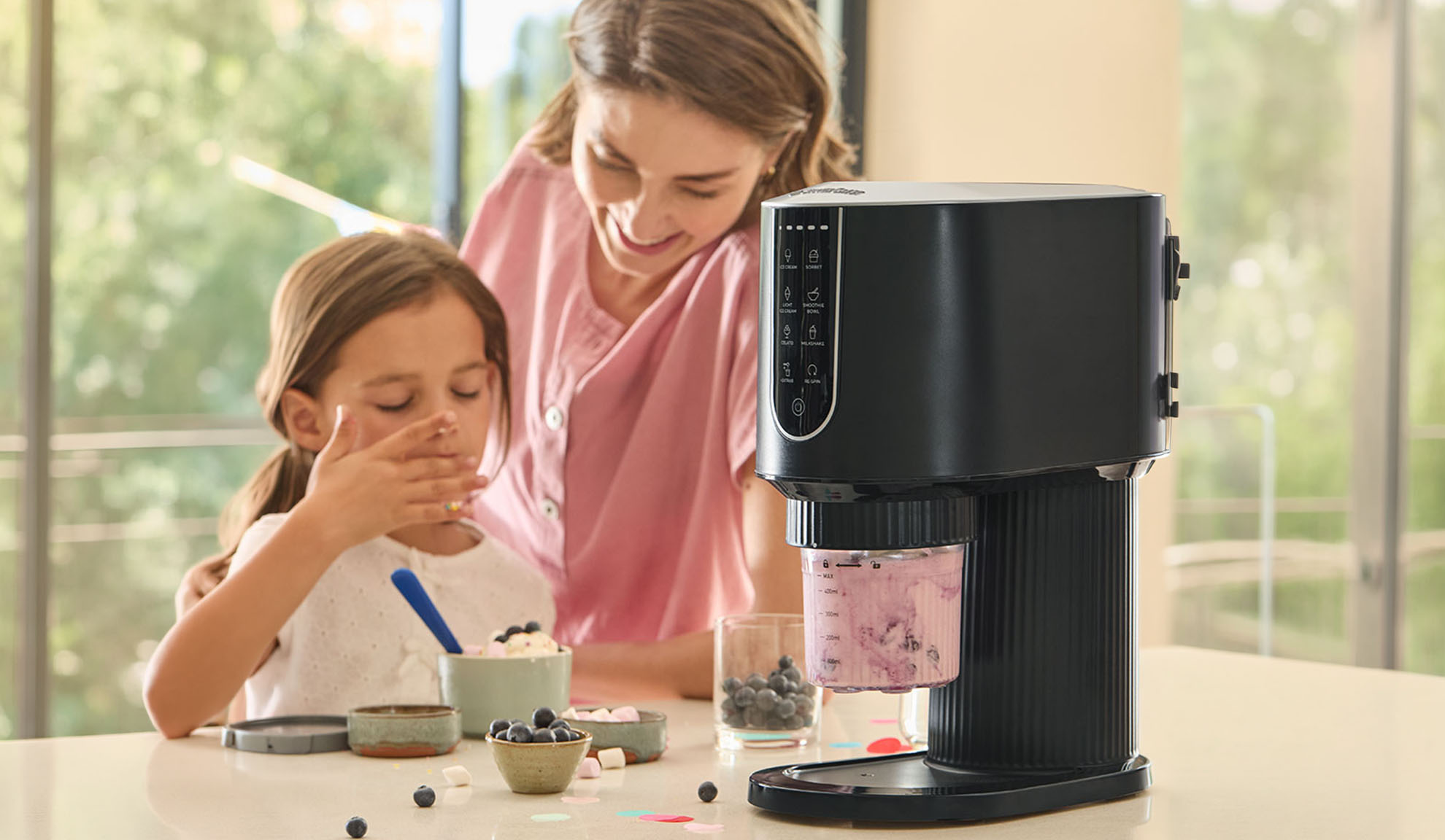 Ice cream maker with a girl and woman making ice cream.