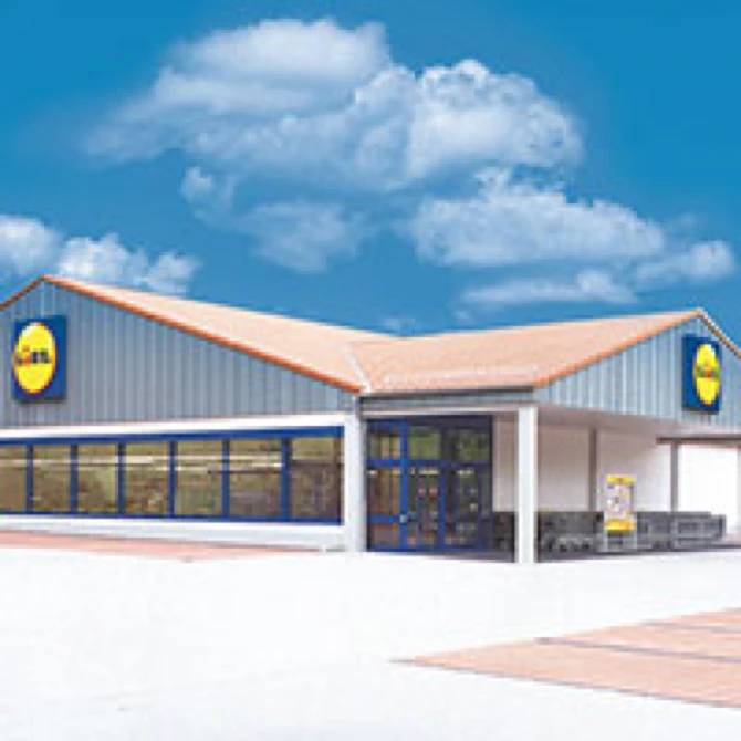 Exterior view of a modern Lidl building with a blue sky and white clouds.